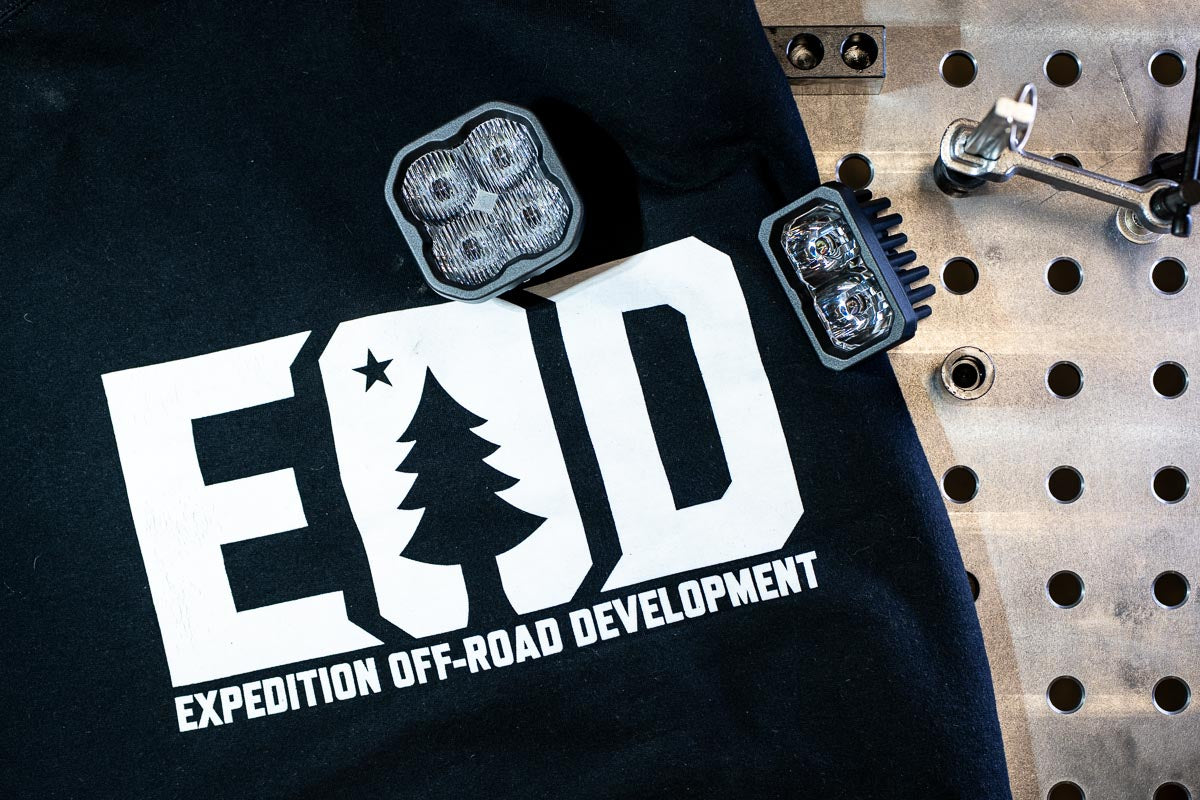 Image with a Expedition Off-Road Development hoodie laying on a welding fixture table with Diode Dynamic pod lights sitting on top